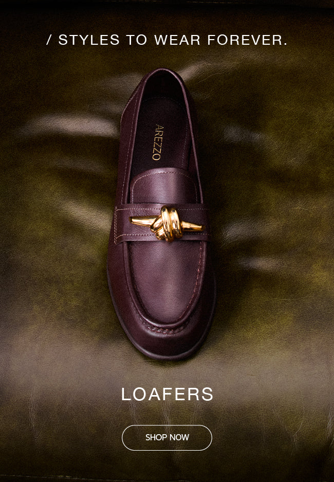 Single burgundy leather loafer with gold hardware detail from Arezzo, placed on a green leather armchair.