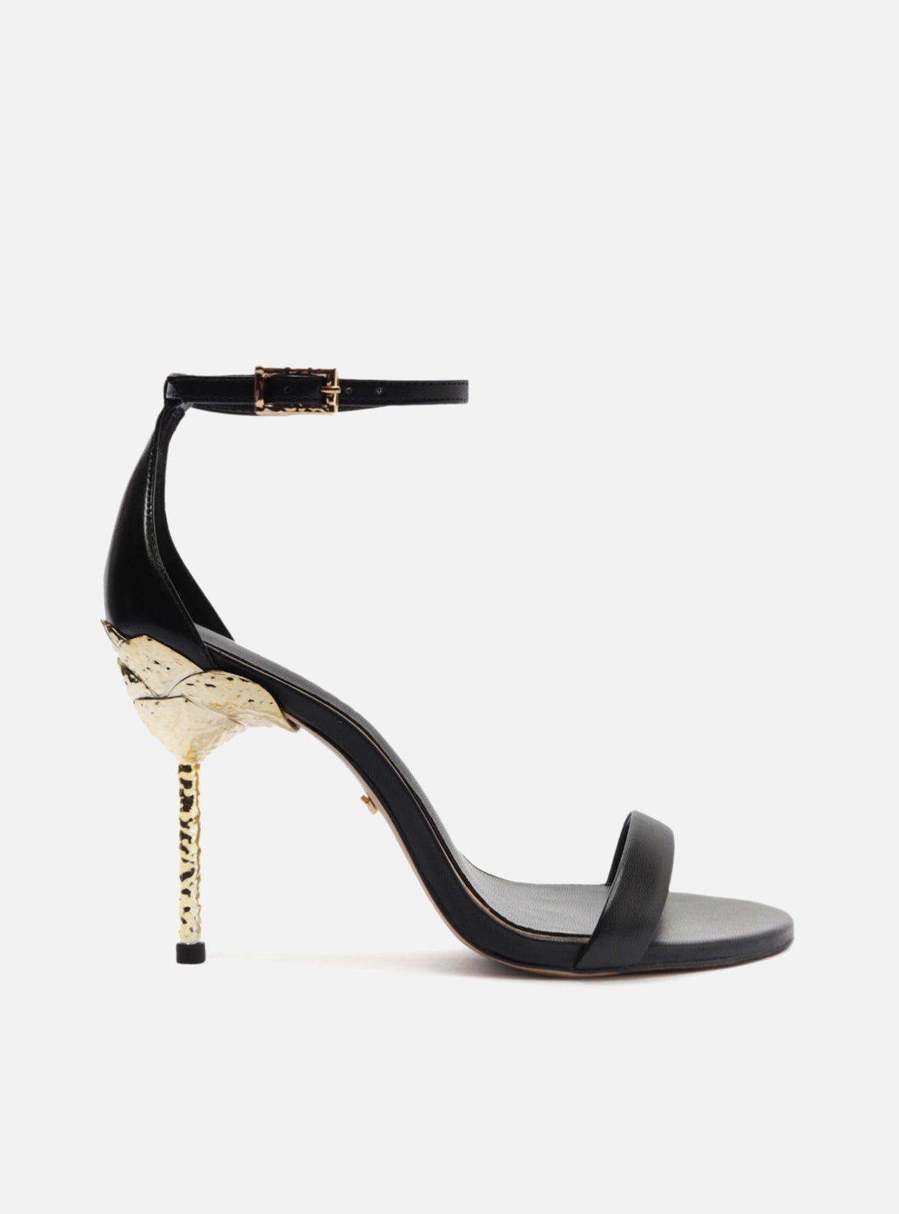 Black leather sandal with a high stiletto heel in hammered gold metal and a rounded toe. Closed heel and ankle strap.