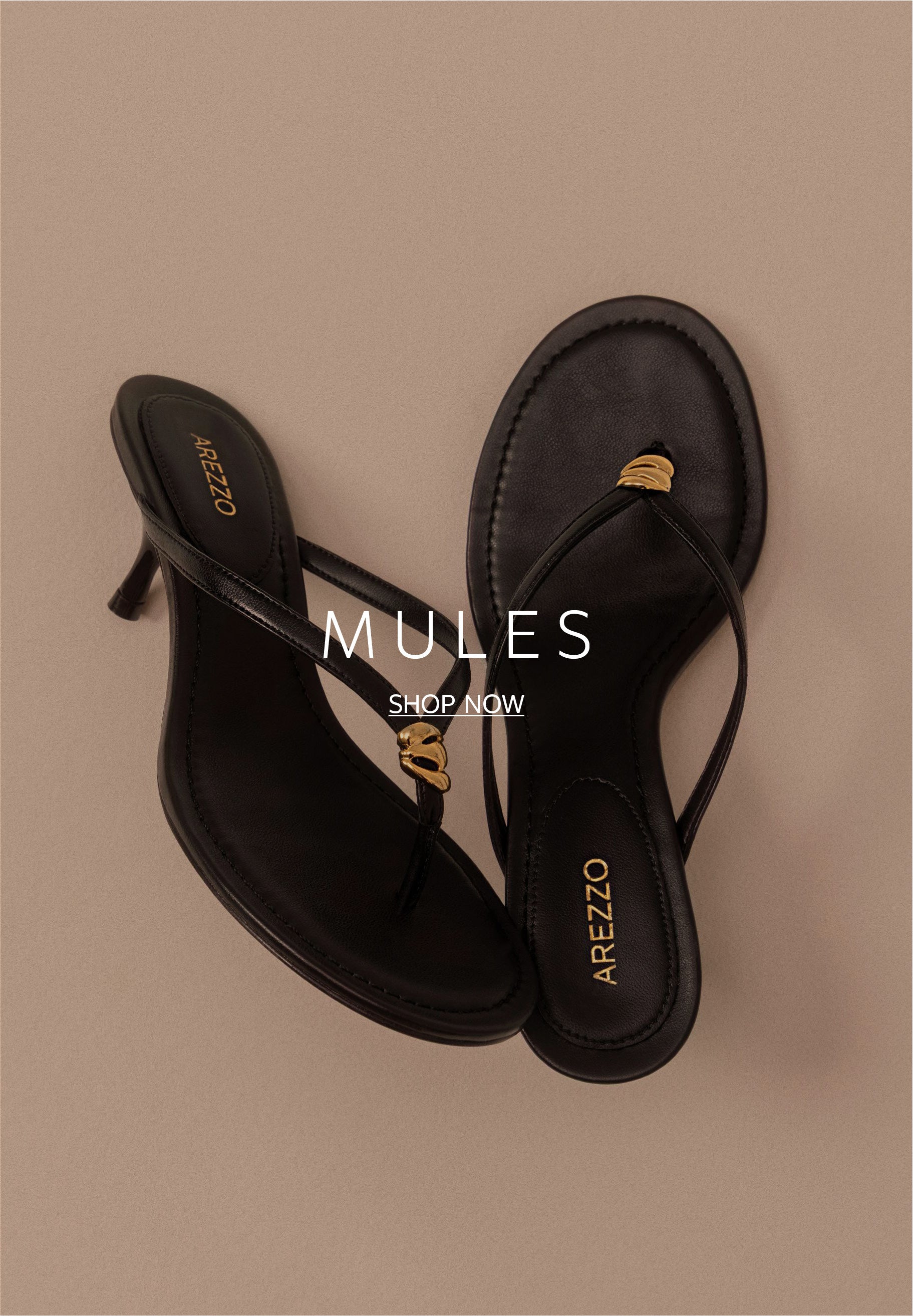 Top-down view of a pair of black high-heeled thong sandals with a mid-height stiletto heel and a small gold metallic accent where the straps meet.