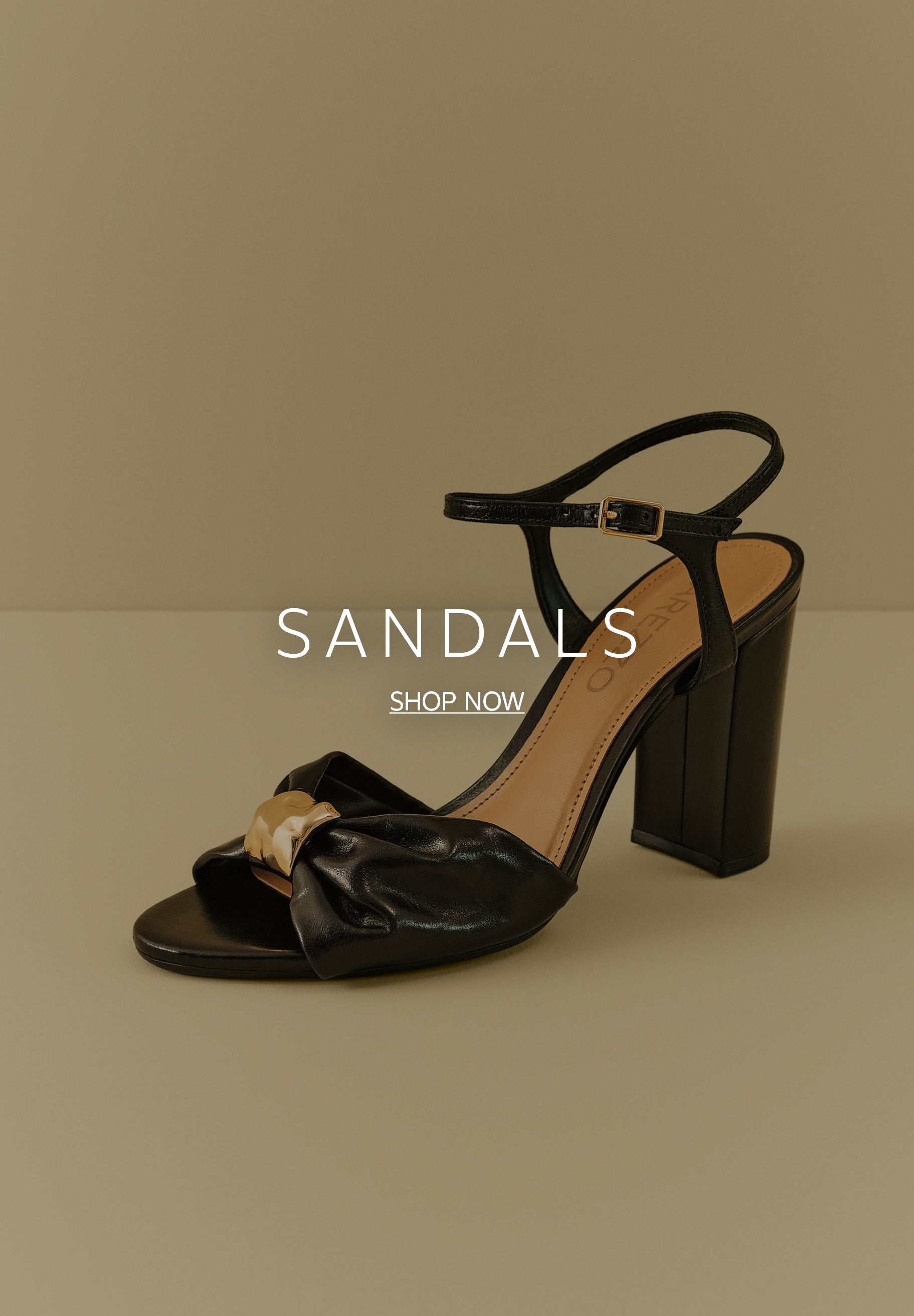 A single black block-heel sandal with a buckled ankle strap resting on a beige background. The front strap features gathered leather detailed with a chunky gold-tone ornament in the center. Large white text reads 